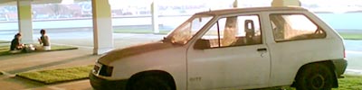 foto von einem weissen auto auf einem parkdeck mit rasenflächen